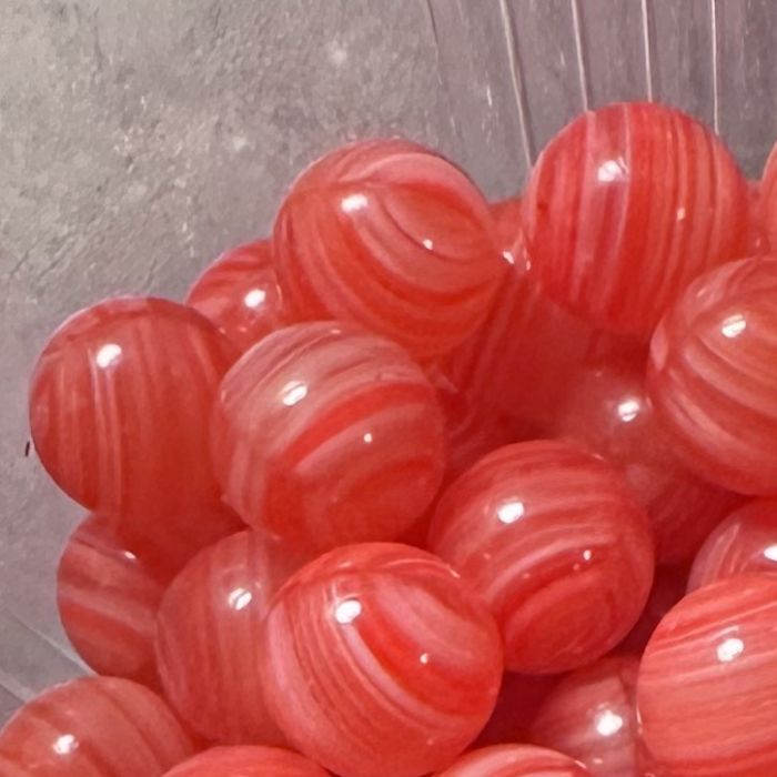 Corail 10mm : petite bille en verre rouge à rayures claires ondulées