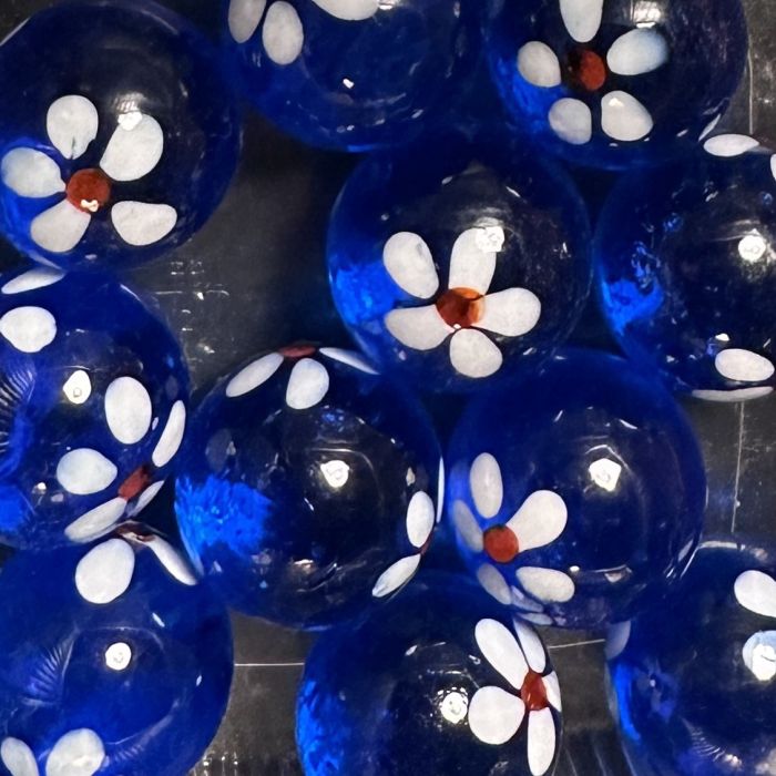 Printemps bleu foncé 25mm : bille faite main en verre bleu foncé translucide avec de petites fleurs blanches au cœur rouge